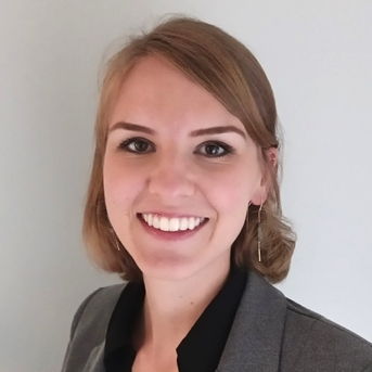 The image shows a headshot of Molly Anderson with shoulder-length straight light-brown hair and smiling. They are dressed in a gray blazer and black top.